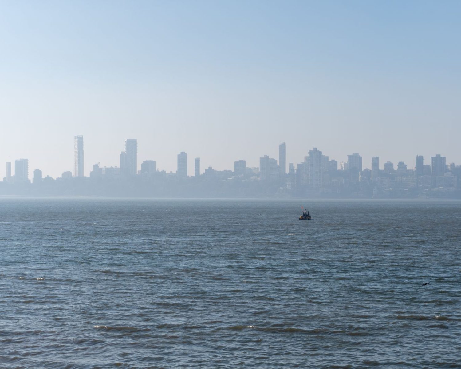 The Mumbai skyline seen across the sea on a clear day.